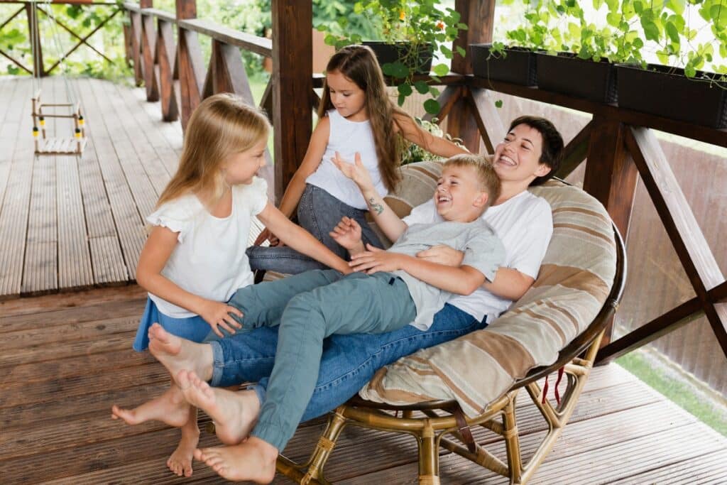 A mother and her kids spending time in the outdoor living space that is an example of one of the deck design trends.